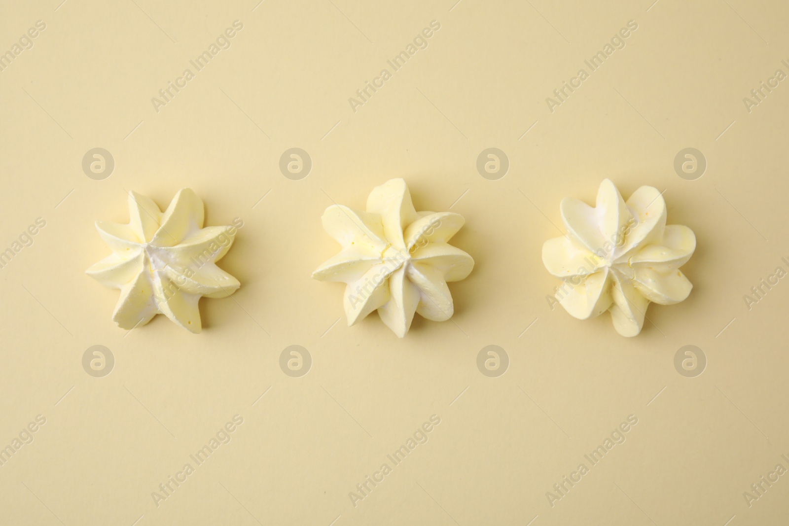 Photo of Delicious meringue cookies on beige background, flat lay