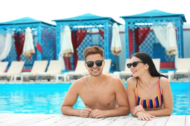 Photo of Woman in bikini with boyfriend at resort. Happy young couple