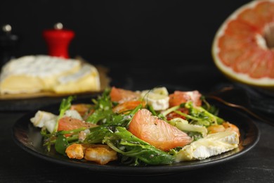 Photo of Delicious pomelo salad with shrimps served on black table