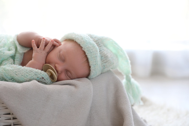 Photo of Cute newborn baby sleeping on plaid in basket. Space for text
