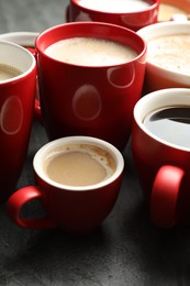 Photo of Many cups of different coffees on grey table, closeup