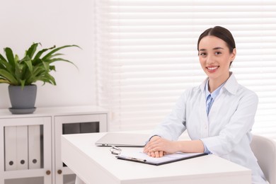 Medical consultant at table in clinic, space for text