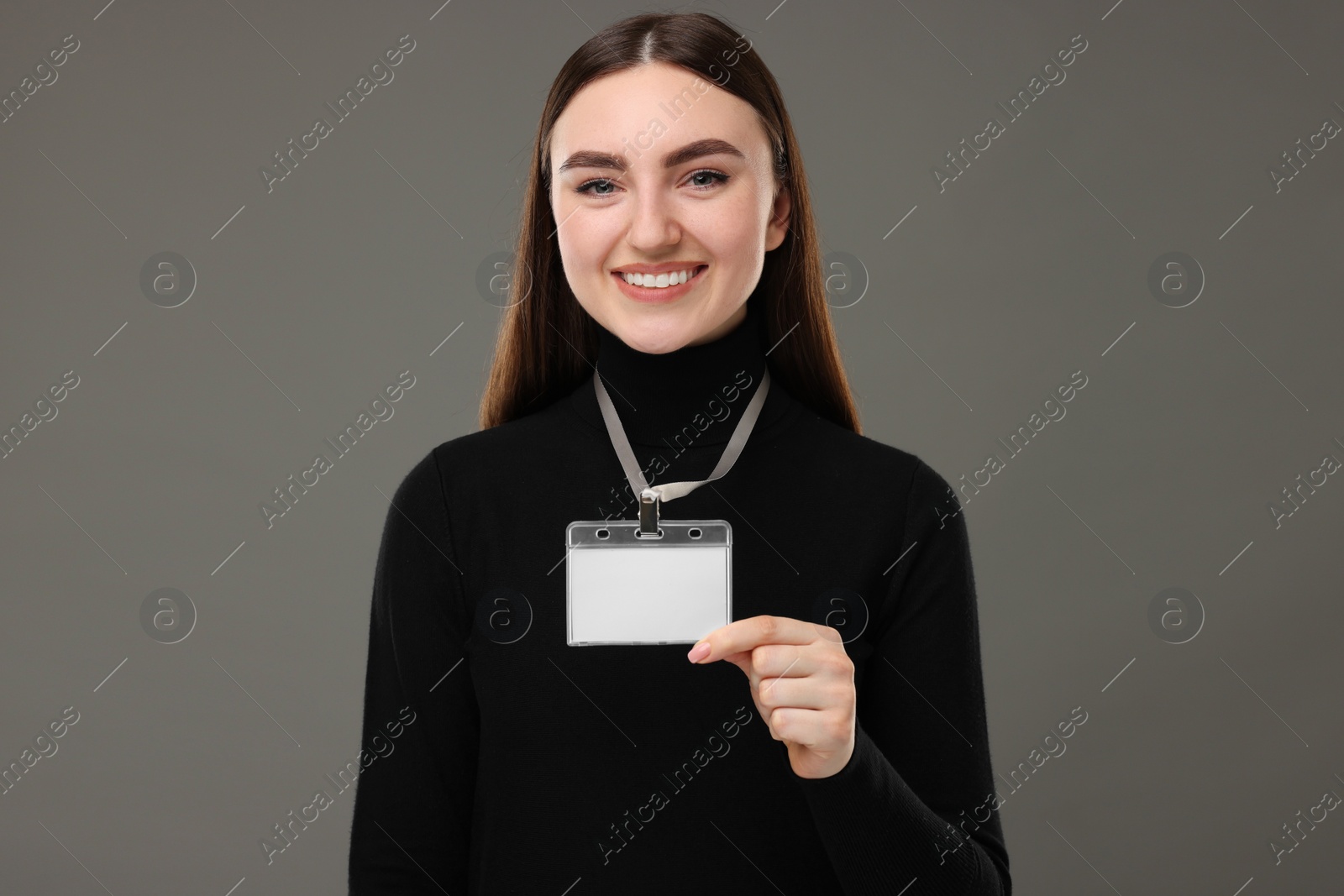 Photo of Happy woman with blank badge on grey background