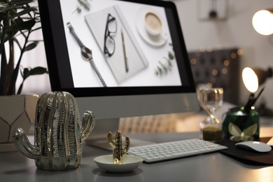 Stylish workplace with modern computer on desk, space for text. Focus on decorative cacti