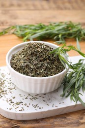 Photo of Dry and fresh tarragon on wooden table