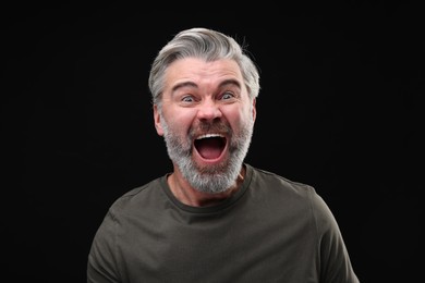 Photo of Personality concept. Emotional man screaming on black background