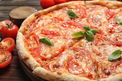 Photo of Delicious pizza Margherita on wooden table, closeup view