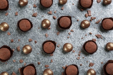 Different delicious chocolate candies on grey table, flat lay