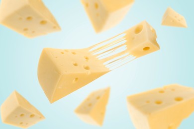 Image of Pieces of cheese falling on light blue background