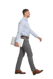 Man with laptop walking on white background