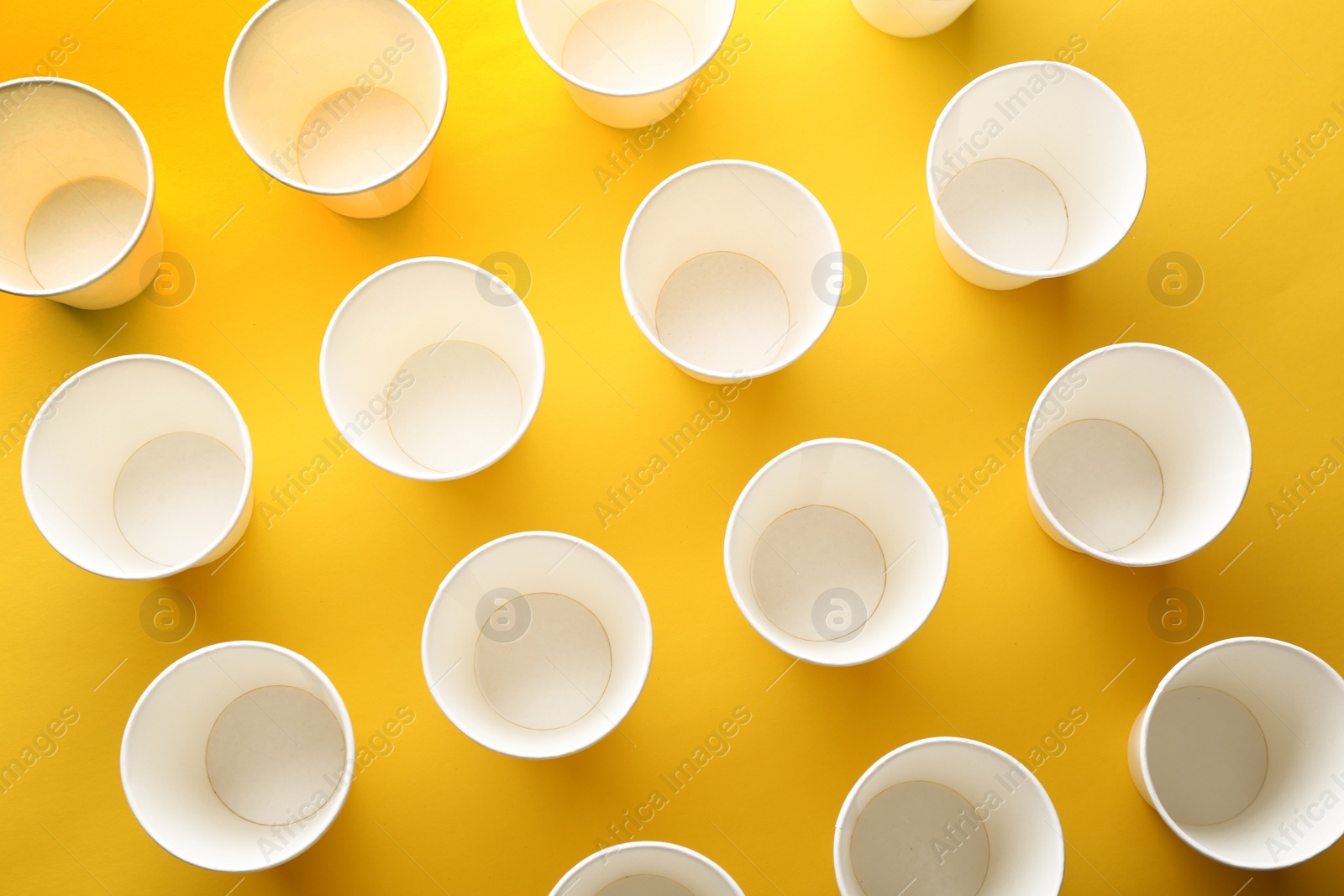 Photo of Paper cups on color background, top view. Picnic table setting