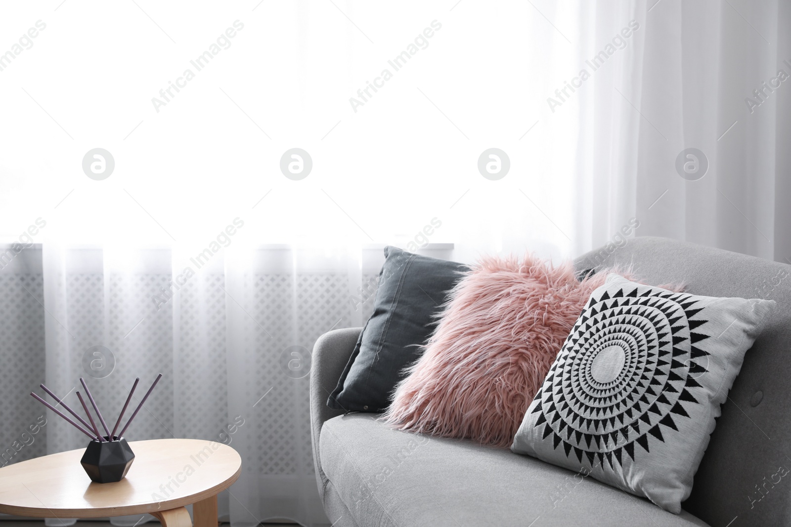 Photo of Soft pillows on modern sofa in living room