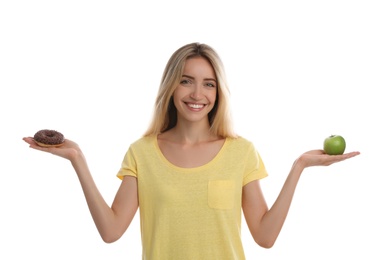 Photo of Woman choosing between doughnut and healthy apple on white background
