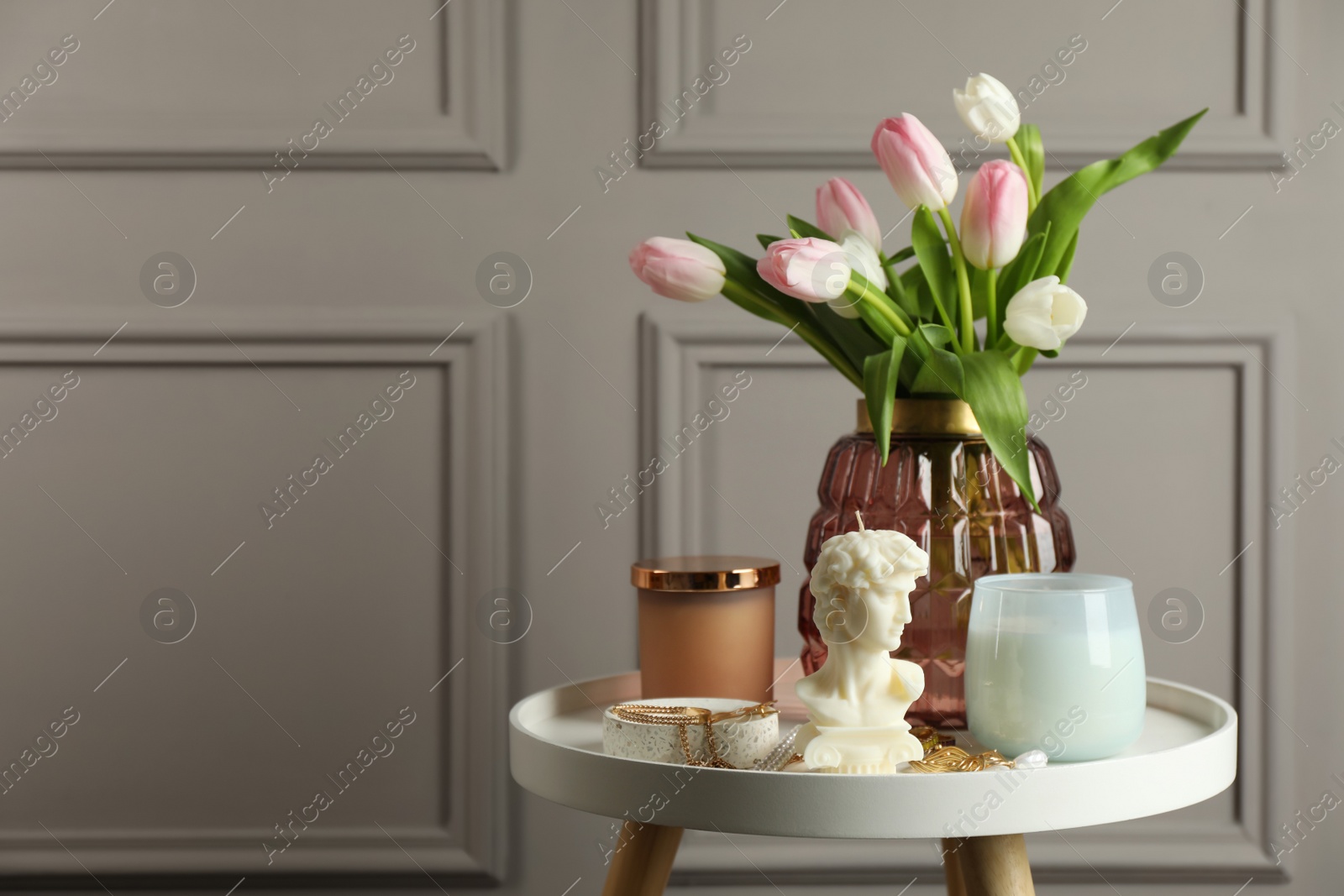 Photo of Beautiful David bust candle, flowers and decor on white table. Space for text