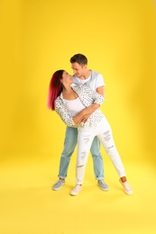 Photo of Beautiful lovely couple dancing on yellow background