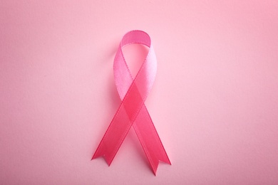 Photo of Pink ribbon on color background, top view. Breast cancer awareness concept