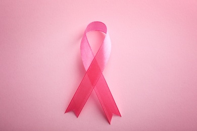 Pink ribbon on color background, top view. Breast cancer awareness concept