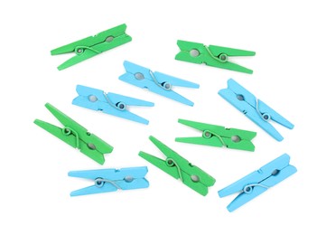 Photo of Many colorful wooden clothespins on white background, top view