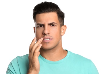 Photo of Man with herpes touching lips against white background