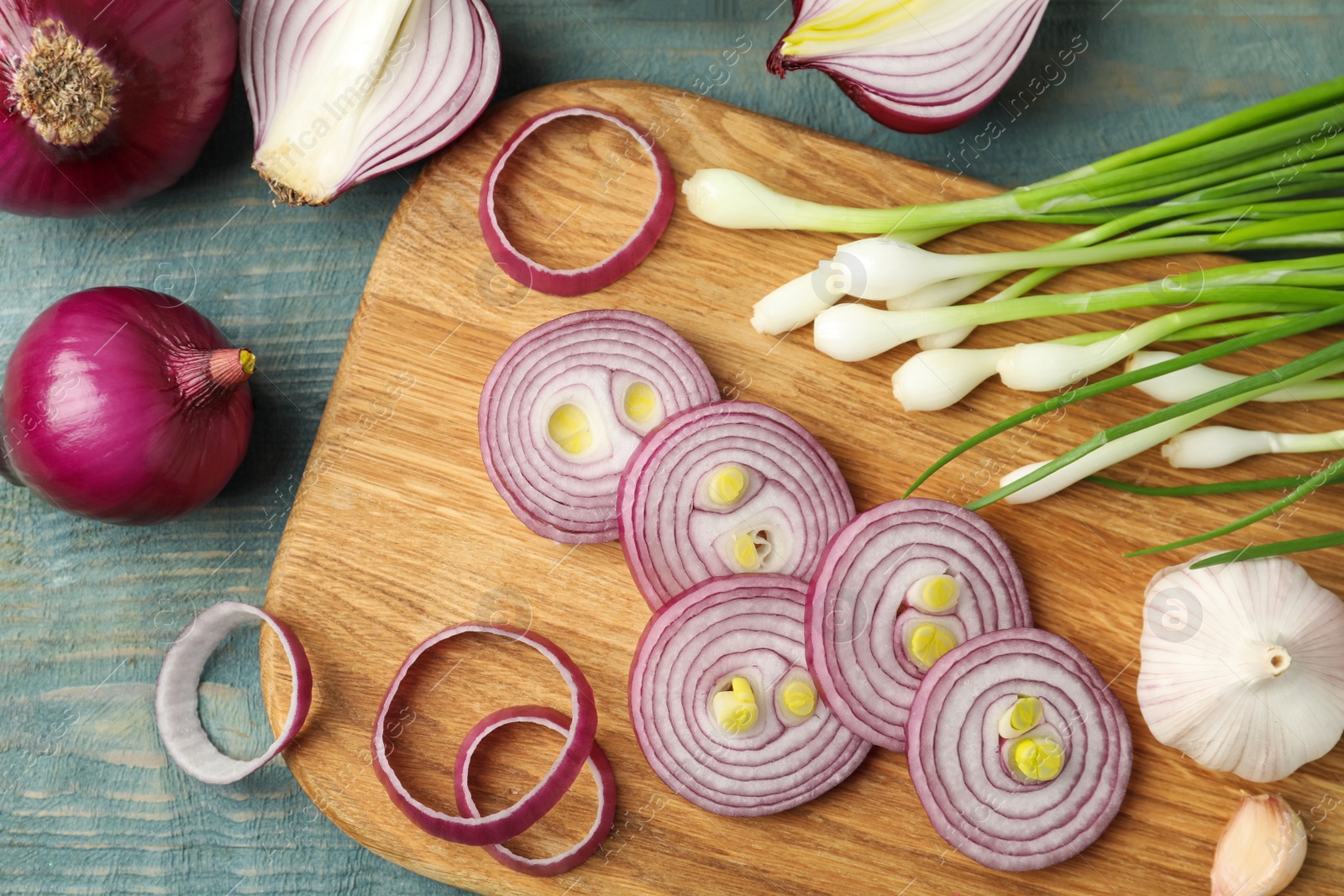 Photo of Flat lay composition with cut red onion on light blue wooden table