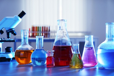 Chemistry glassware with liquids on table in laboratory