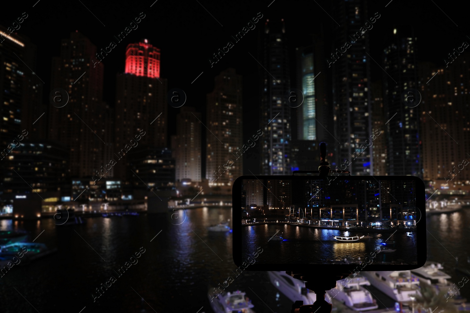 Image of DUBAI, UNITED ARAB EMIRATES - NOVEMBER 03, 2018: Night cityscape of marina district. Taking photo with camera mounted on tripod