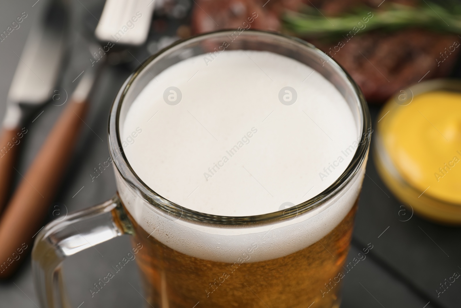 Photo of Mug of tasty beer on table, closeup view