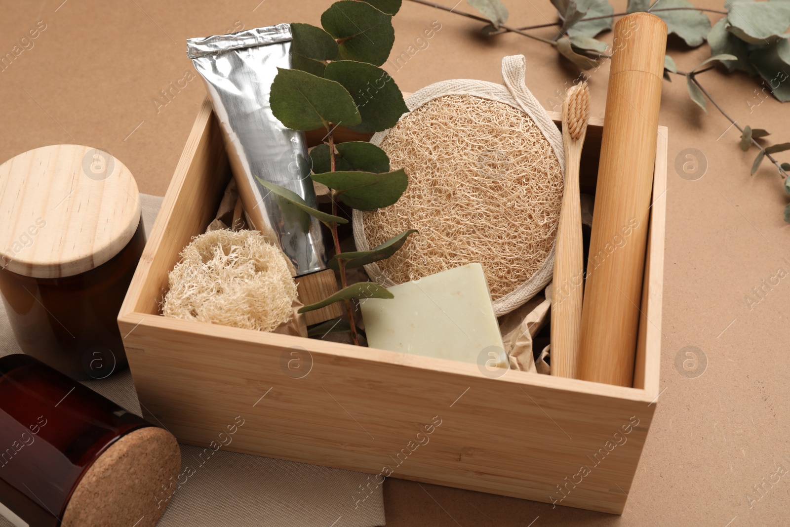 Photo of Wooden box with eco friendly products on craft paper, closeup