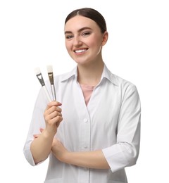 Cosmetologist with cosmetic brushes on white background