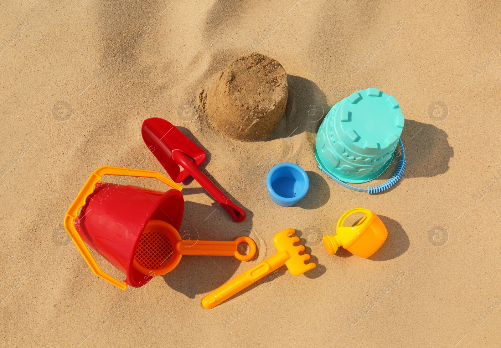 Photo of Set of plastic beach toys on sand. Outdoor play