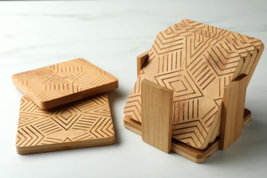 Stylish wooden cup coasters on light table