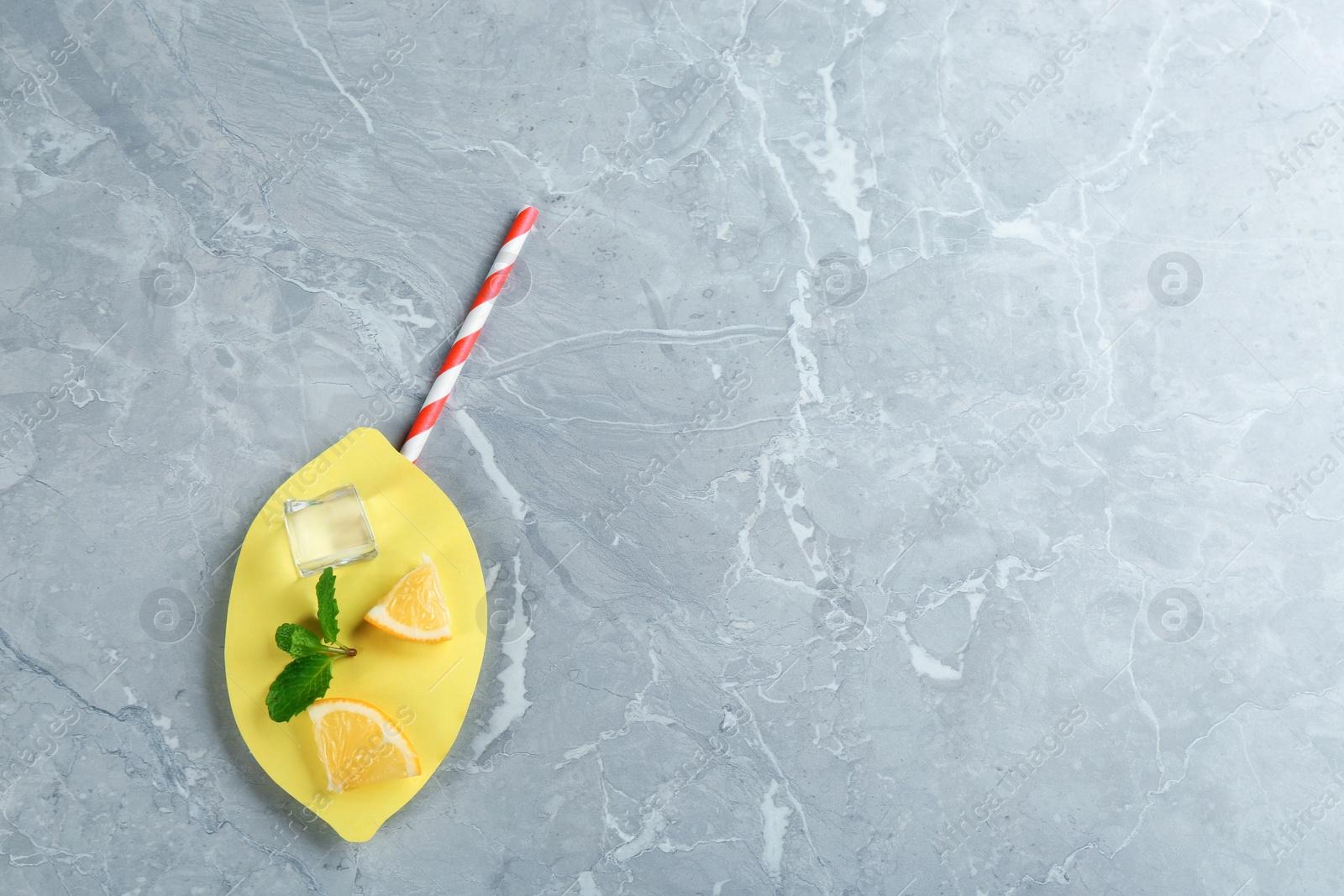 Photo of Creative lemonade layout with lemon slices, mint and ice on grey marble table, top view. Space for text