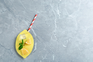 Photo of Creative lemonade layout with lemon slices, mint and ice on grey marble table, top view. Space for text