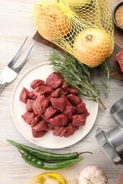 Pieces of beef and products on white wooden table, flat lay