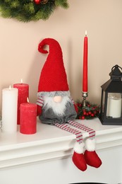 Photo of Cute Christmas gnome and festive decor on fireplace at home