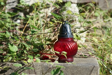 Photo of Red grave lantern on tombstone outdoors, space for text