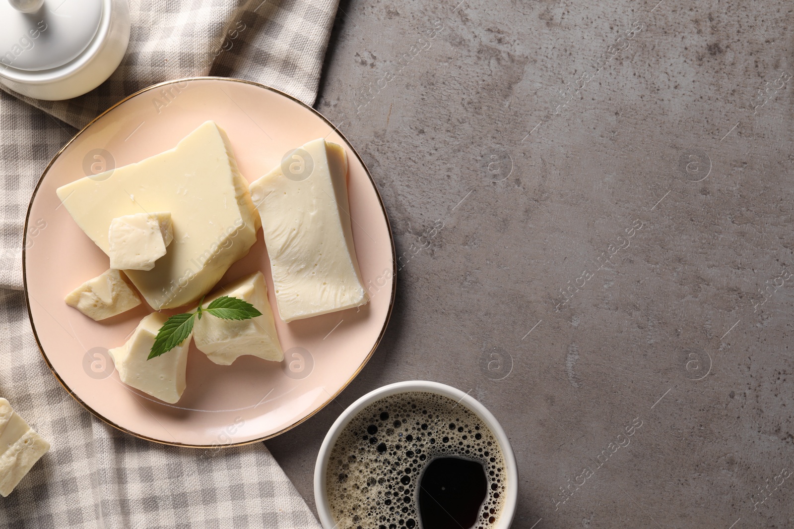 Photo of Pieces of tasty white chocolate, mint and coffee on grey textured table, top view. Space for text