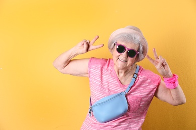 Portrait of cool grandmother on color background, space for text