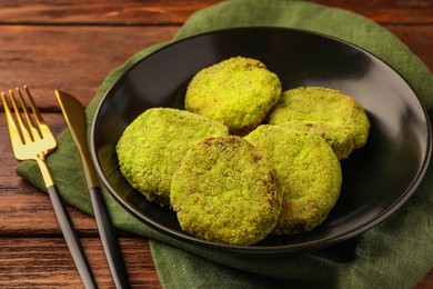 Tasty vegan cutlets served on wooden table, closeup