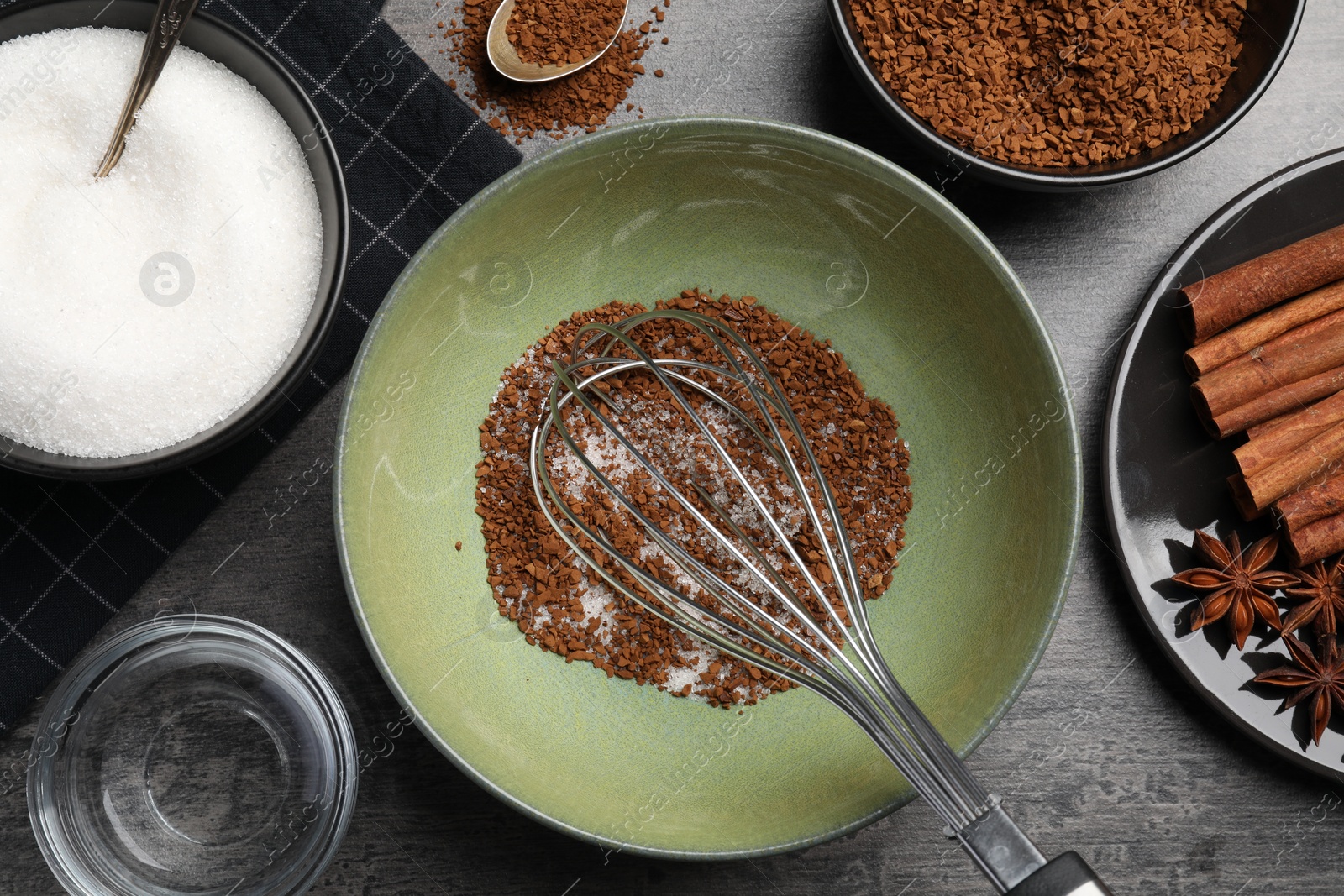 Photo of Making dalgona coffee. Instant granules, sugar, cinnamon sticks, anise stars and whisk on table, flat lay