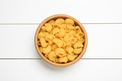 Photo of Raw macaroni pasta in bowl on white wooden table, top view