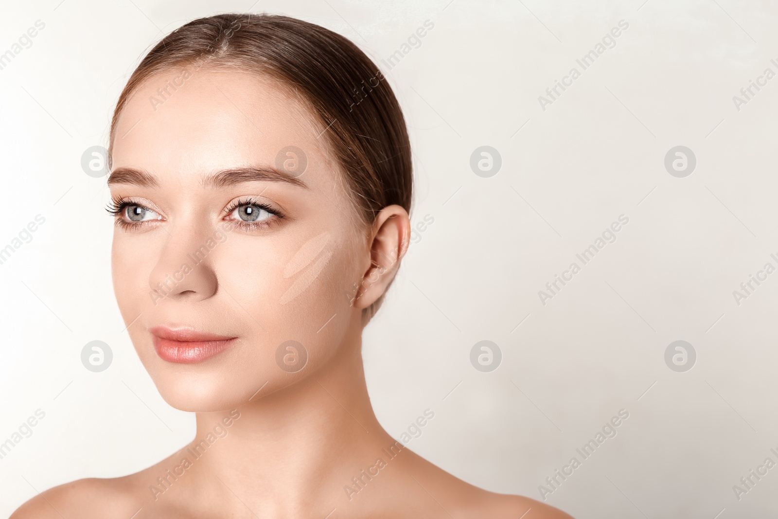 Photo of Portrait of beautiful young woman with makeup smears on face against white background