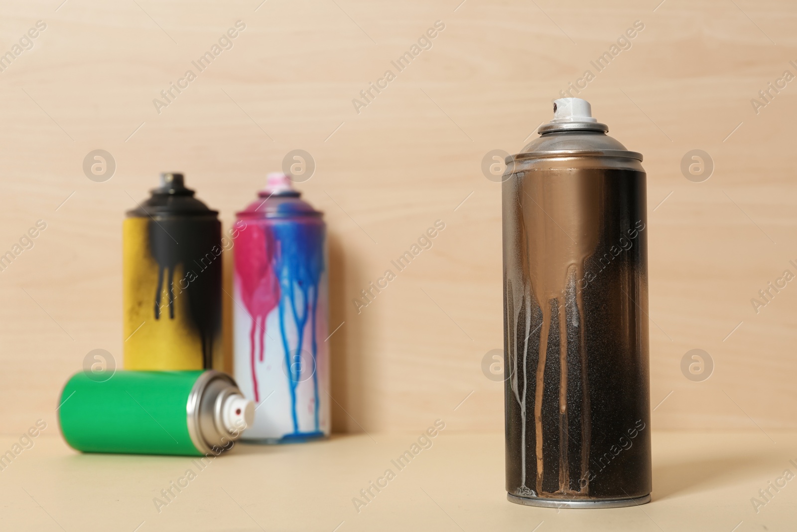 Photo of Used cans of spray paint on wooden background. Space for text