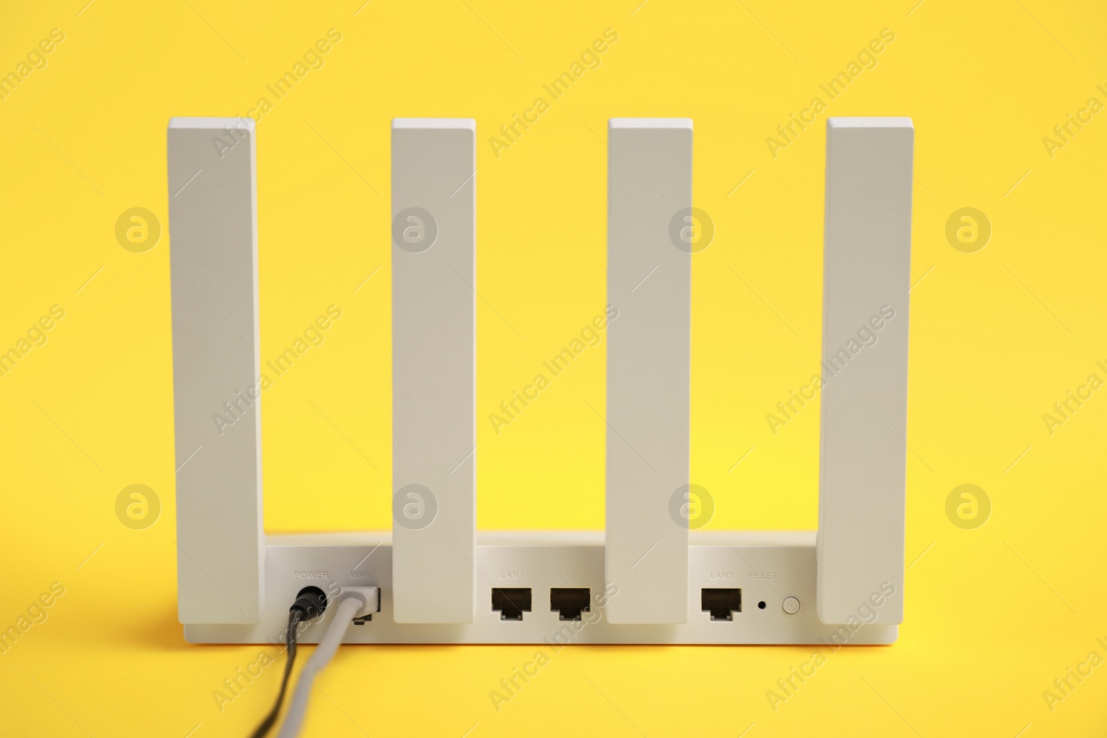 Photo of One modern Wi-Fi router on yellow background