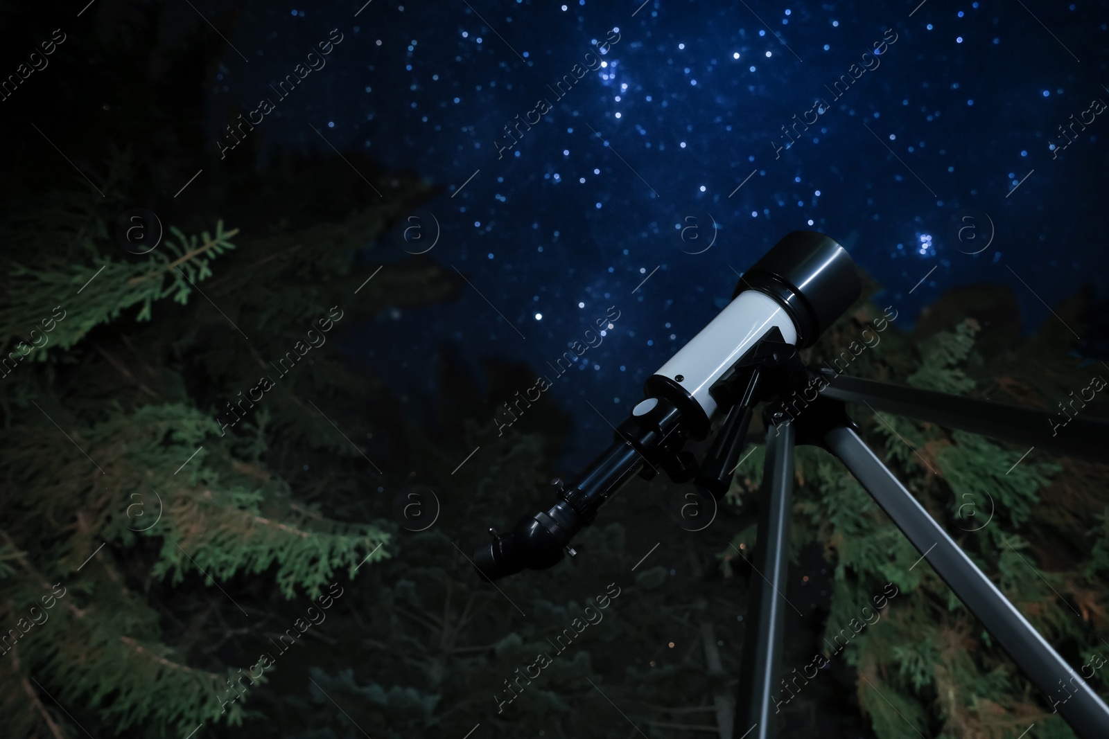 Photo of Modern telescope at night outdoors, low angle view. Learning astronomy