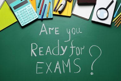 Photo of Green chalkboard with phrase Are You Ready For Exams and different stationery, flat lay
