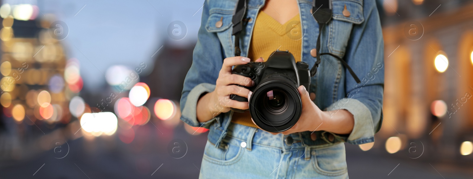 Image of Professional photographer with modern camera and blurred view of beautiful city in evening. Banner design
