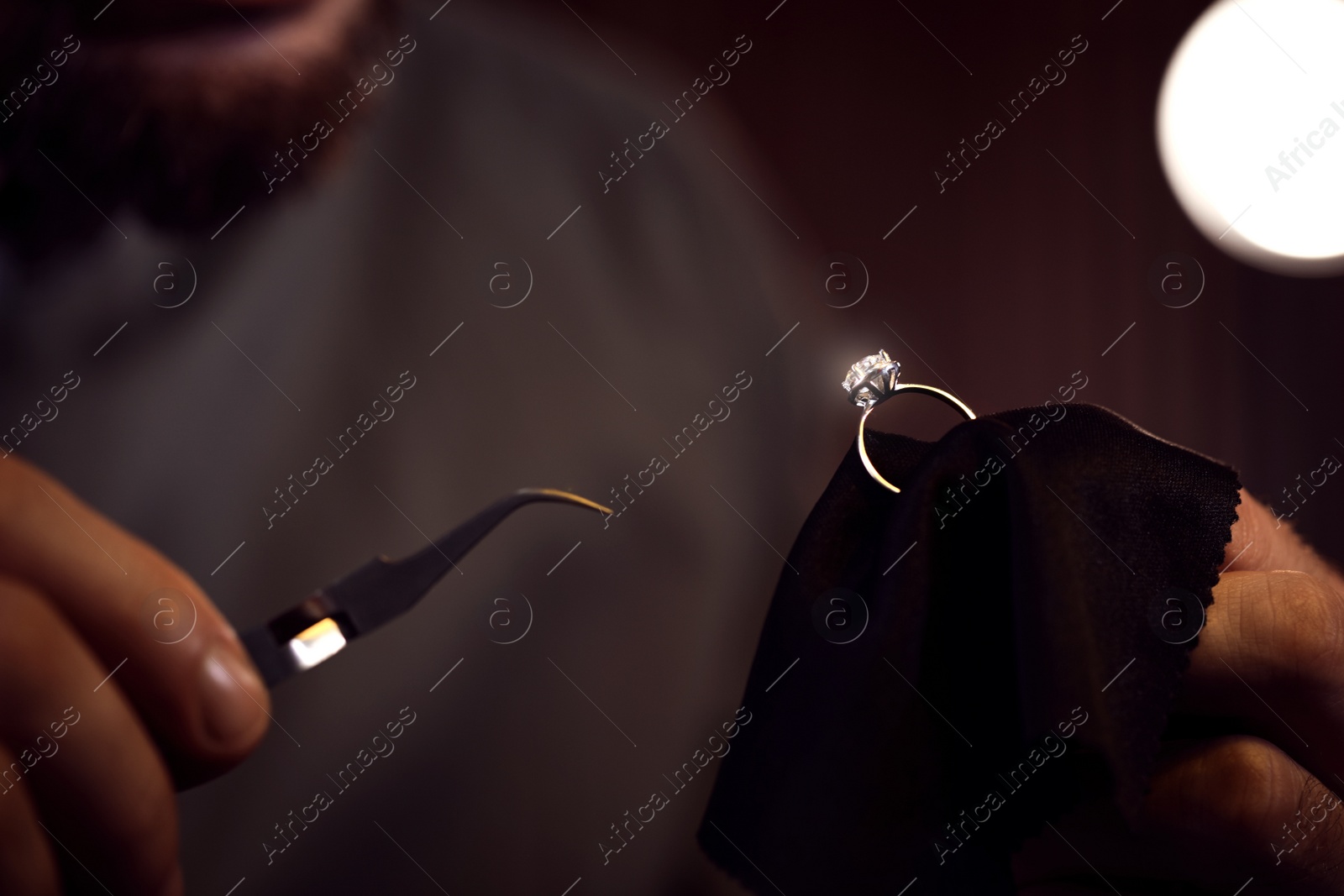 Photo of Jeweler working with ring on blurred background, closeup