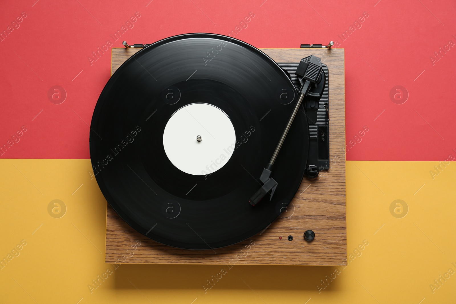 Photo of Turntable with vinyl record on color background, top view