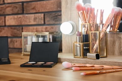 Photo of Cosmetic and brushes on dressing table in makeup room